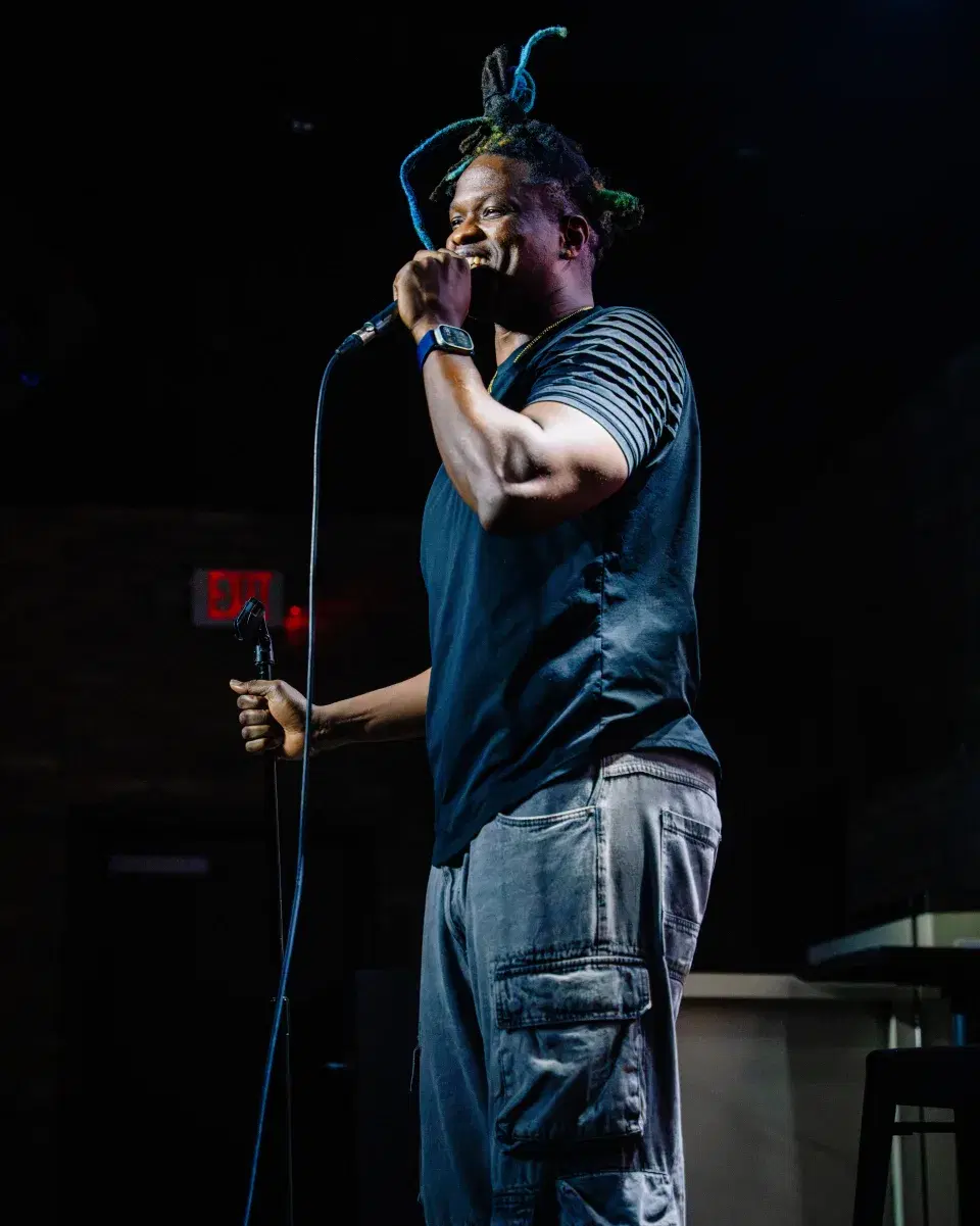 Fredo Louis smiling during a live stand-up set